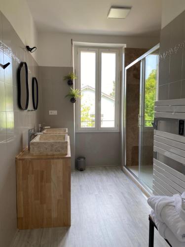 a bathroom with a sink and a glass shower at Gîte à Villeréal avec spa in Villeréal