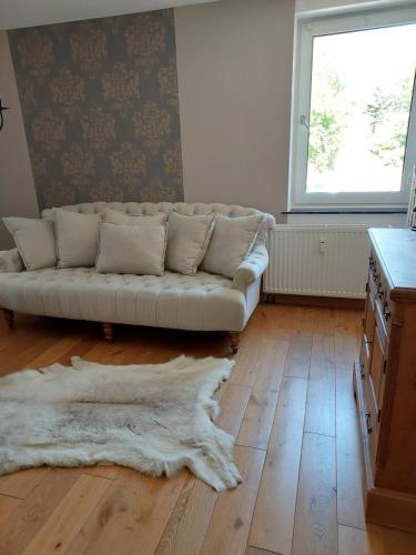 a living room with a white couch and a wooden floor at private apartment in Kürten