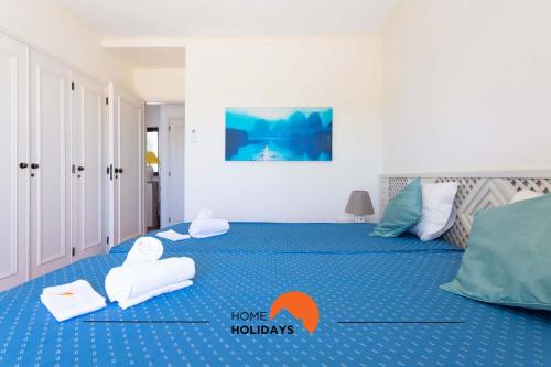 1 Schlafzimmer mit 2 Betten und Handtüchern auf dem Boden in der Unterkunft #151 Kid Friendly, AC with Pool and Golf Course in Albufeira