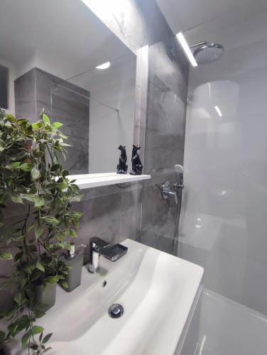 a bathroom with a white sink and a shower at Apartman Ivan in Kaštela