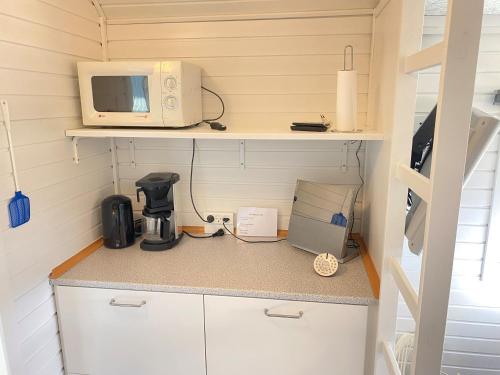 a kitchen with a microwave and a coffee maker at Gård hytter in Tønder
