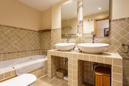 łazienka z 2 umywalkami i wanną w obiekcie Luxurious and spacious apartment with a private garden and solarium with great views in Estepona área Marbella La Resina Country Golf w mieście Estepona