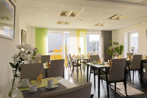 a dining room with tables and chairs and windows at Hotel im Kornspeicher in Marburg an der Lahn