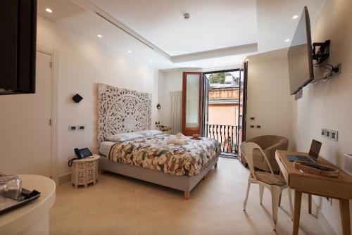a bedroom with a bed and a table and a desk at Corvaja Inn in Taormina