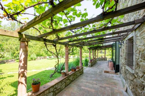 a pergola on the side of a building with potted plants at Casa Palmira in Polcanto