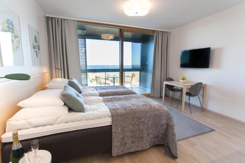 a bedroom with a large bed with a view of the ocean at Santa's Resort & Spa Hotel Sani in Kalajoki
