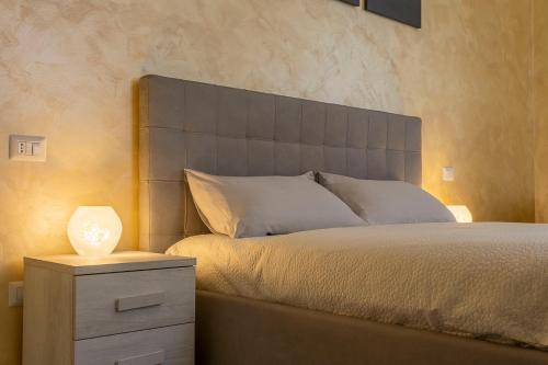 Leader Apartment 2 في ميلانو: غرفة نوم مع سرير وطاولة مع مصباح
