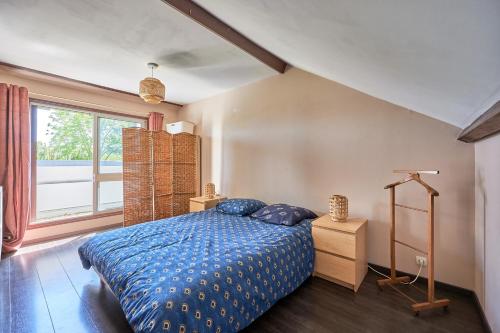 a bedroom with a blue bed and a window at Les Roséales - Maison proche plage pour 6 voyageurs in Courseulles-sur-Mer