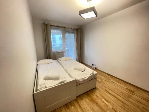 Cama pequeña en habitación con ventana en Apartament Park Zakrzowek en Cracovia
