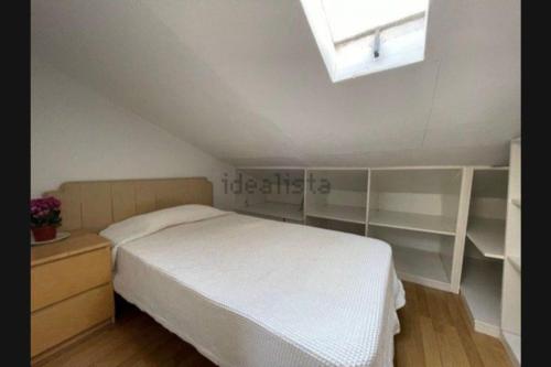 a bedroom with a bed and shelves and a window at San Bernabé, apartamento para 2 en las Vistillas junto a metro Puerta de Toledo in Madrid