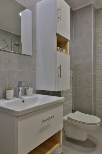 a bathroom with a white sink and a toilet at antonis apartment in Katerini