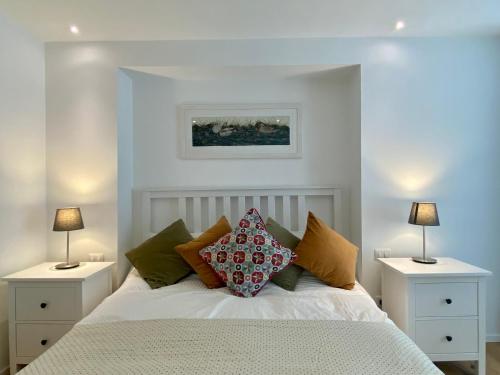 una camera con un letto bianco con due comodini di Casa Marina a Radda in Chianti