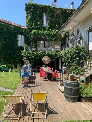 una terrazza in legno con sedie e un tavolo di fronte a una casa di " Venez DormiR Chez Nous " #Condom#Gascogne#d'Artagnan#Armagnac#Le Bonheur est dans le GERS a Condom