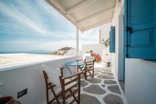 un patio con sedie e un tavolo sul balcone. di Alcyone a Serifos Chora