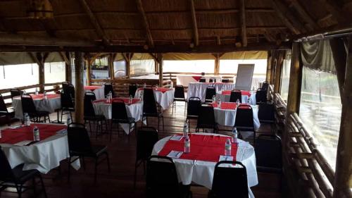 un grupo de mesas y sillas con servilletas rojas. en Sky Beach Hotel, en Wakiso