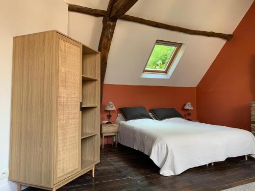 een slaapkamer met een groot bed en oranje muren bij L'Authentique maison de charme in Aubusson