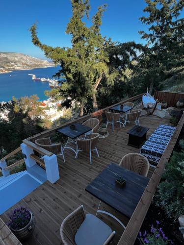 a deck with tables and chairs and a view of the water at Spongia Apartments Kalymnos in Kalymnos