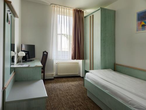 a bedroom with a bed and a desk with a computer at Lipa, Hotel & Bistro in Nova Gorica