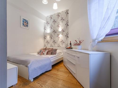 ザコパネにあるVisitZakopane - Aquapark Residence Violet Apartmentの小さなベッドルーム(ベッド1台、ドレッサー付)