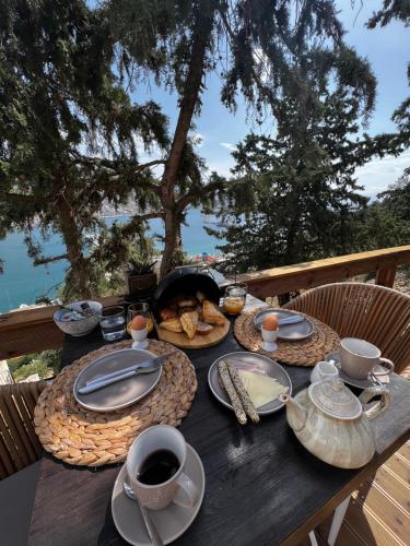 una mesa de madera con comida y café. en Spongia Apartments Kalymnos, en Kalymnos