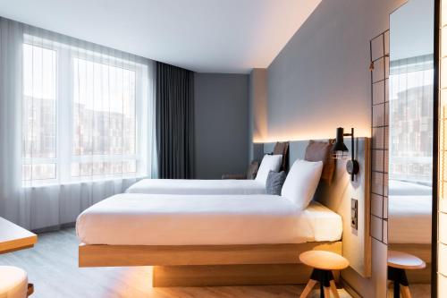 - une chambre avec 2 lits et une grande fenêtre dans l'établissement Moxy The Hague, à La Haye
