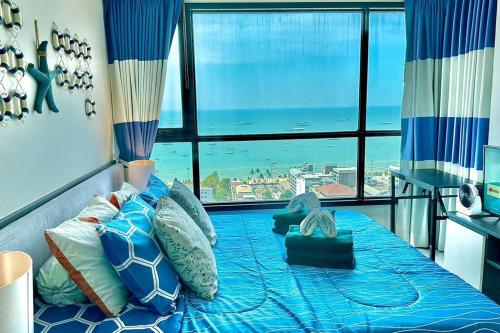 a bedroom with a bed with a view of the ocean at The BASE Central PATTAYA 2Bed on Sky in Pattaya Central