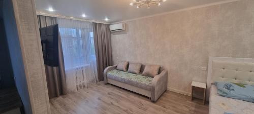 una pequeña sala de estar con sofá y TV en 1 комнатная квартира со всеми удобствами, en Baljash
