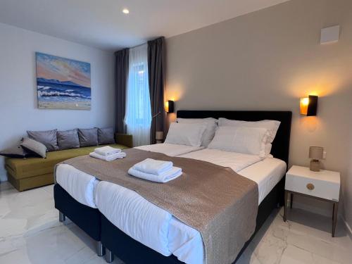 a bedroom with a large bed with towels on it at Azalea Dalmacija Luxury Rooms and Apartments in Primošten