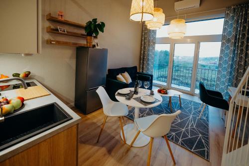 a kitchen and living room with a table and chairs at RentPlanet - Apartamenty Zarembowicza II in Wrocław