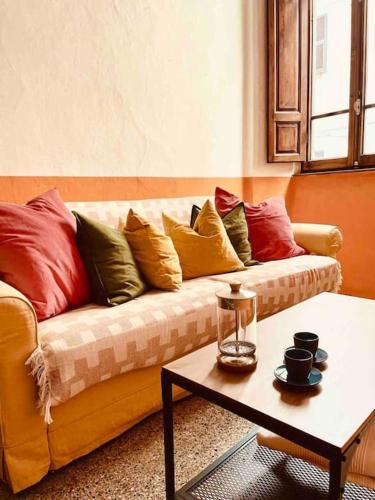 sala de estar con sofá amarillo y almohadas coloridas en Small Town House in Tuscany, en Pontremoli