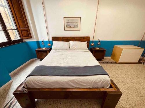 Cama en habitación con 2 mesitas de noche y cama sidx sidx sidx sidx en Small Town House in Tuscany, en Pontremoli
