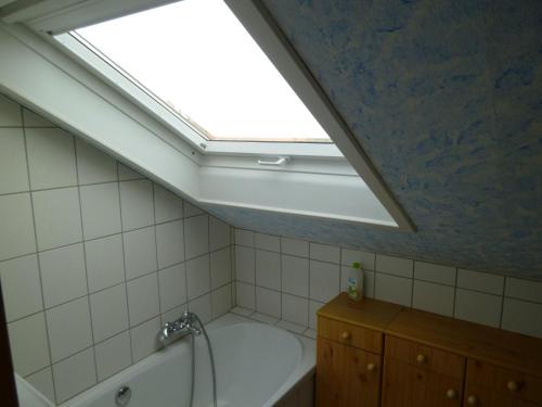 ein Badezimmer mit einem Dachfenster und einer Badewanne in der Unterkunft Ferienwohnung Gäckle in Bad Liebenzell