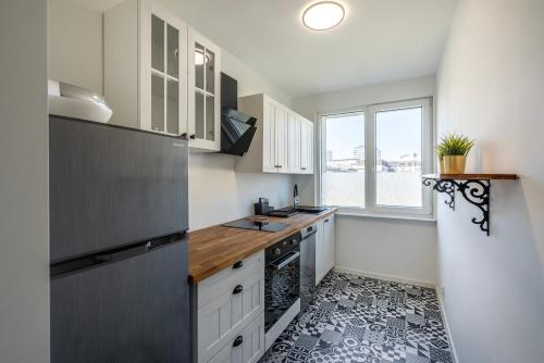 a kitchen with white cabinets and a black and white floor at 13 Gdynia Centrum - Apartament Mieszkanie dla 5 os in Gdynia