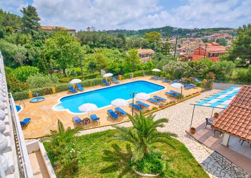 an overhead view of a swimming pool with chairs and umbrellas at Hotel Olga in Agios Stefanos