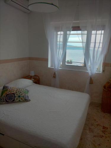 Schlafzimmer mit einem Bett und einem Fenster mit Meerblick in der Unterkunft Notti sul mare a Villa Chiara in Marina di Casalvelino