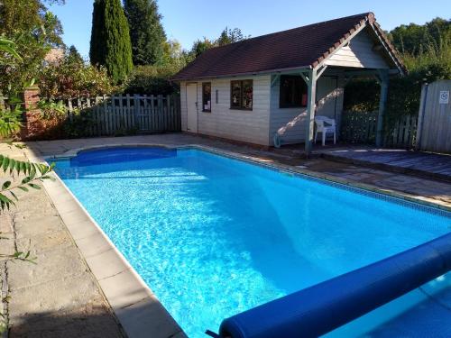 a swimming pool in a yard with a house at Secluded cosy cottage in Newbury