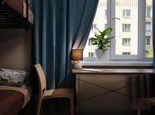 a bedroom with a window with a plant on a desk at Хостел єЖитло Щекавиця in Kyiv