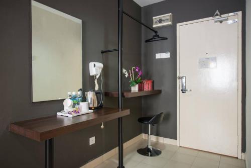 La salle de bains est pourvue d'une coiffeuse, d'un miroir et d'une chaise. dans l'établissement SC Hotel Melaka, à Malacca