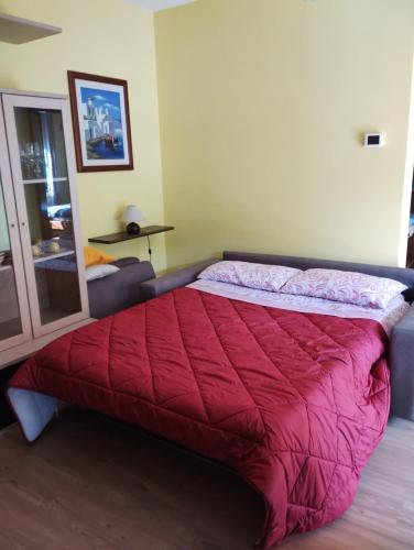 um quarto com uma cama com um edredão vermelho em Parco Madonnetta em Acilia