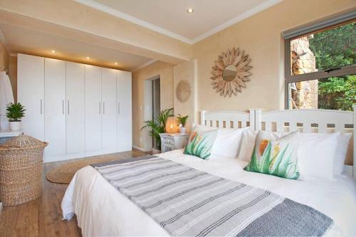 sypialnia z dużym białym łóżkiem i oknem w obiekcie Vitamin-Sea w Kapsztadzie