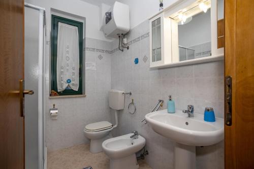 La salle de bains est pourvue d'un lavabo, de toilettes et d'un miroir. dans l'établissement La casa di Marigiò, à Piraino