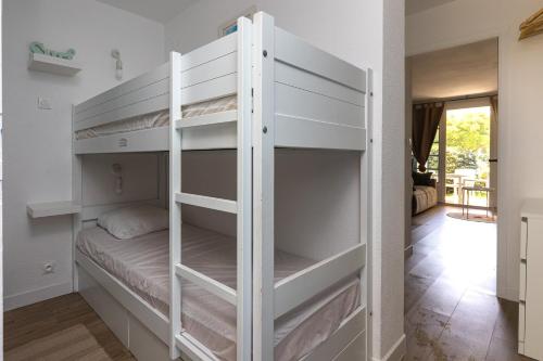 białe łóżko piętrowe w pokoju w obiekcie Appartement Olivia w mieście Moliets-et-Maa