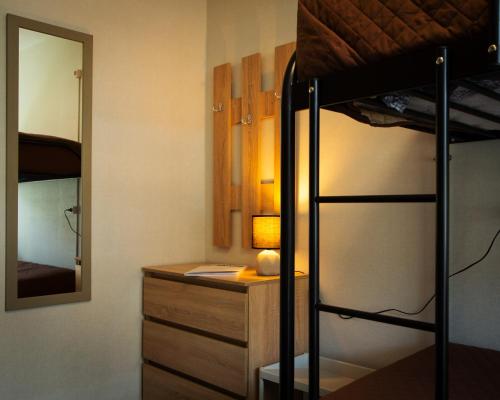a bedroom with a bunk bed and a desk with a mirror at Хостел єЖитло Щекавиця in Kyiv