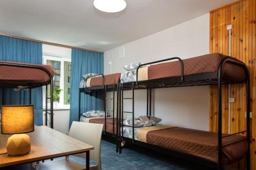 a room with three bunk beds and a table at Хостел єЖитло Щекавиця in Kyiv