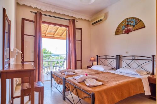 Schlafzimmer mit einem Bett, einem Tisch und einem Fenster in der Unterkunft Hotel Olga in Agios Stefanos