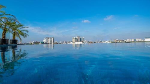 a large swimming pool with a city in the background at The Lapis Hotel in Hanoi