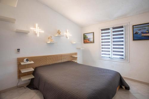 um quarto com uma cama e uma janela em Le Mas d Emponse em Plan-de-la-Tour