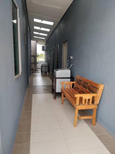a hallway with a wooden bench in a building at Yasmeen Studio Roomstay Kijal - Room 2 - FOR TWO PERSON ISLAM GUEST ONLY in Kijal