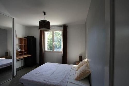 une chambre avec un lit blanc et une fenêtre dans l'établissement Villa Roquefortoise avec piscine, à Roquefort-les-Pins