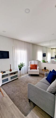 a living room with a couch and a tv at Ninho Citadino Aveiro in Aveiro